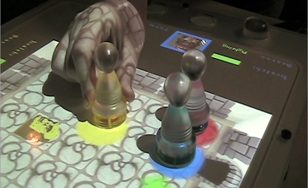 Players use tagged physical pawns to move their characters around the virtual space