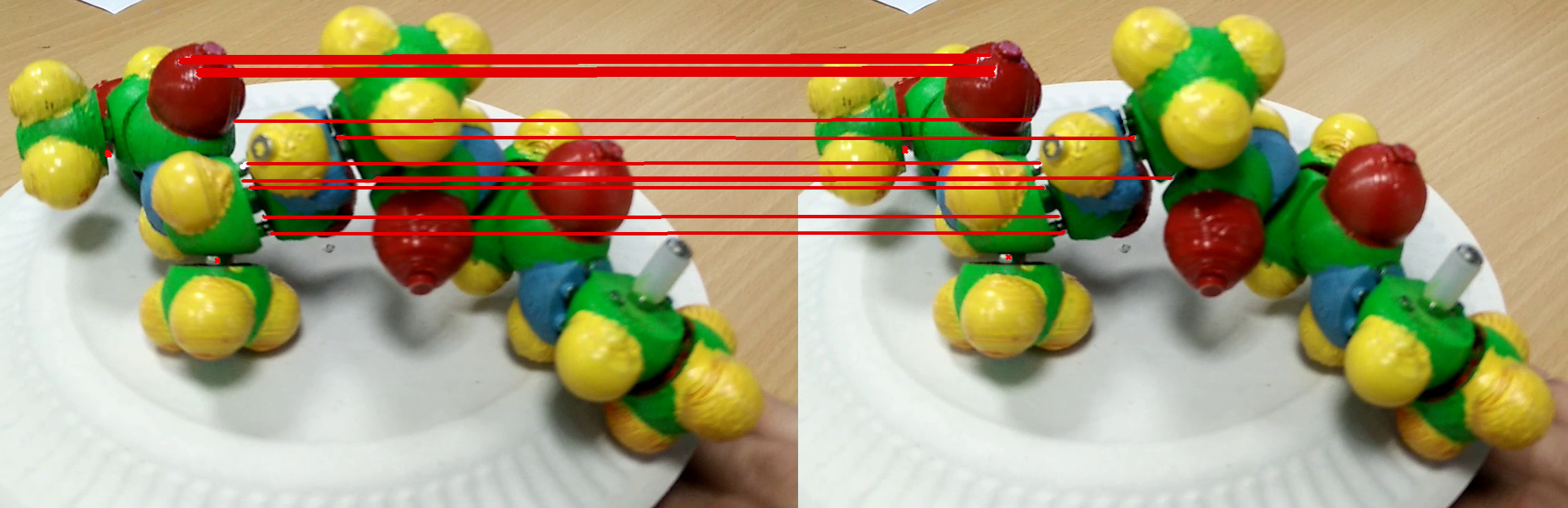 Figure 8: OpenCV ORB feature points matching between two frames of a video of the moving physical model. Specularities, shadows and links between atoms are the only points tracked. Moreover, points are not uniformly distributed over the protein.