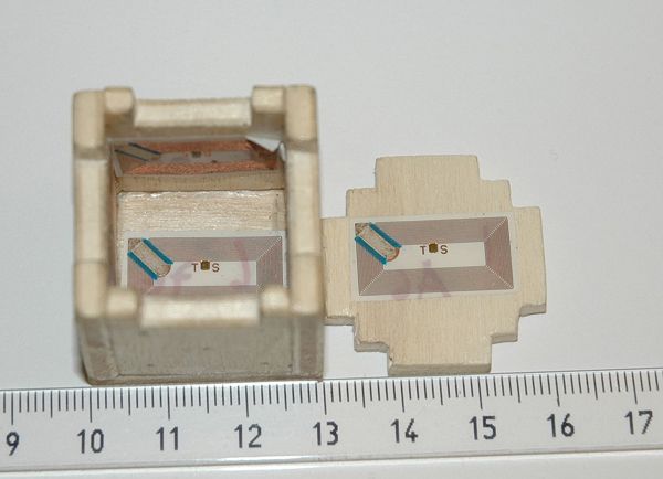The small die opened up disclosing the attached RFID tags. The scale on the ruler is centimeter.